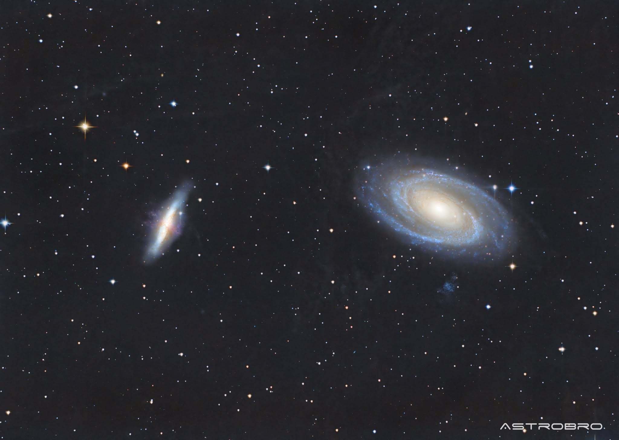 Galaxies M81 et M82 photographiées au télescope : à droite la spirale de Bode aux bras bleutés autour d'un noyau doré, à gauche la galaxie du Cigare vue par la tranche avec ses jets de matière rougeâtres.