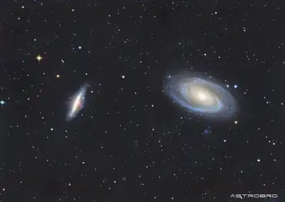 Galaxies M81 et M82 photographiées au télescope : à droite la spirale de Bode aux bras bleutés autour d'un noyau doré, à gauche la galaxie du Cigare vue par la tranche avec ses jets de matière rougeâtres.
